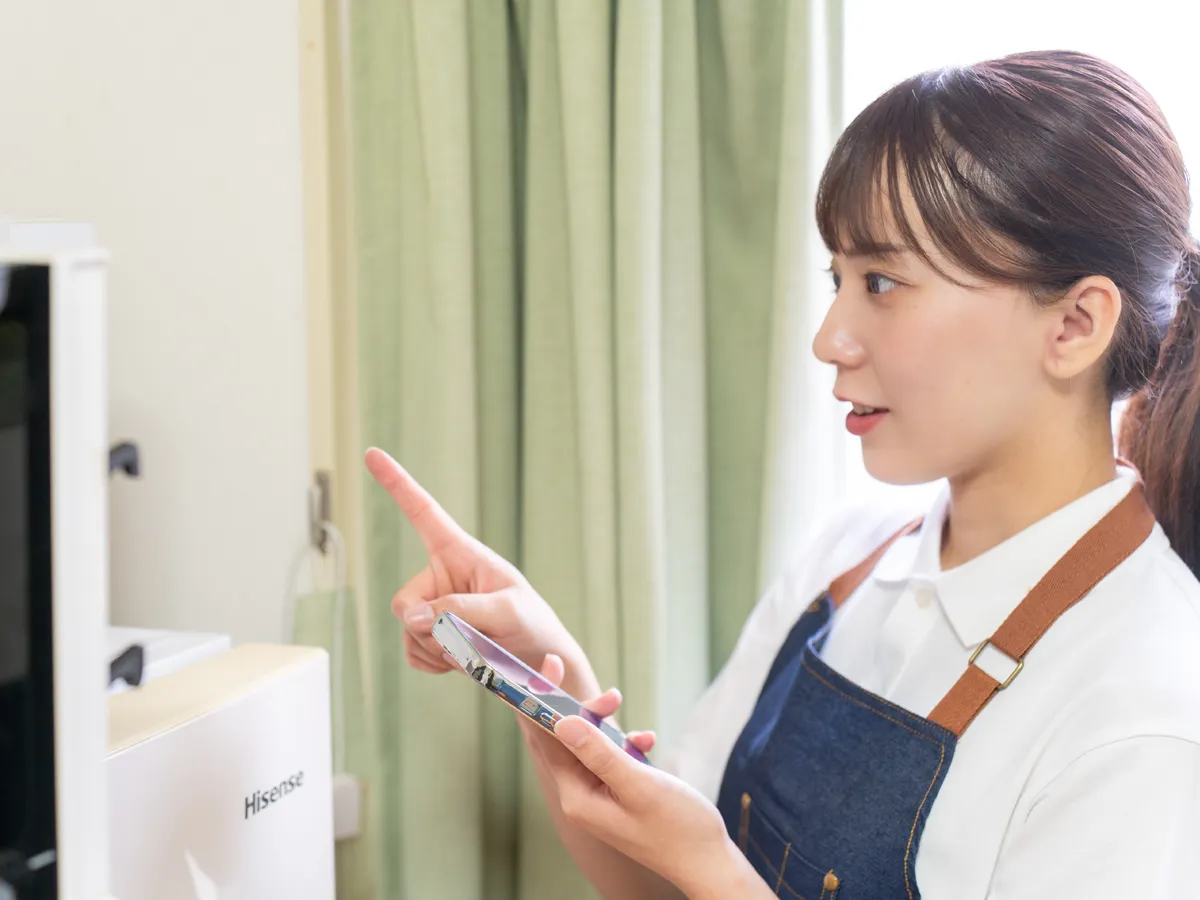 スマートフォンで清掃作業の完了報告を行うスタッフ